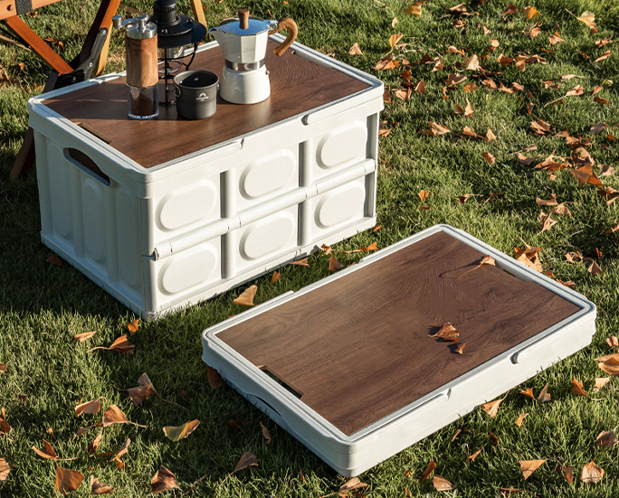 Folding storage bin with drinks on wooden lid, used outdoors on grass