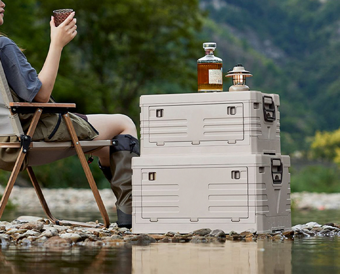 Camper enjoying drinks next to stackable crates by the water