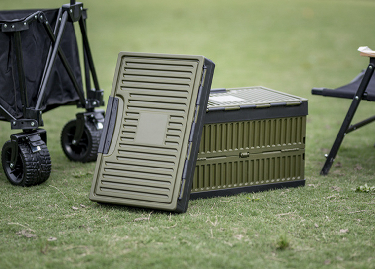 Army green foldable storage box with upright lid placed outdoors