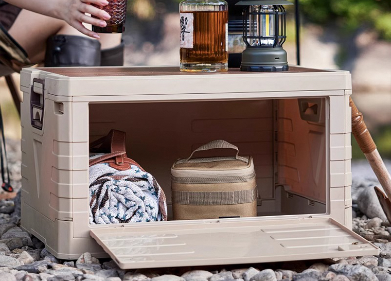 Folding storage crate used as camp table with lighting and drinks
