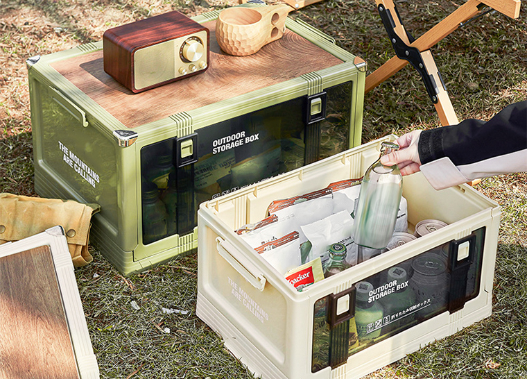 Green and beige outdoor storage boxes in use during camping.