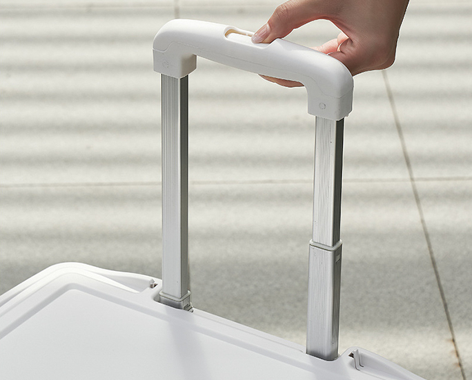 Close-up of hand holding the telescopic handle of a foldable trolley storage box