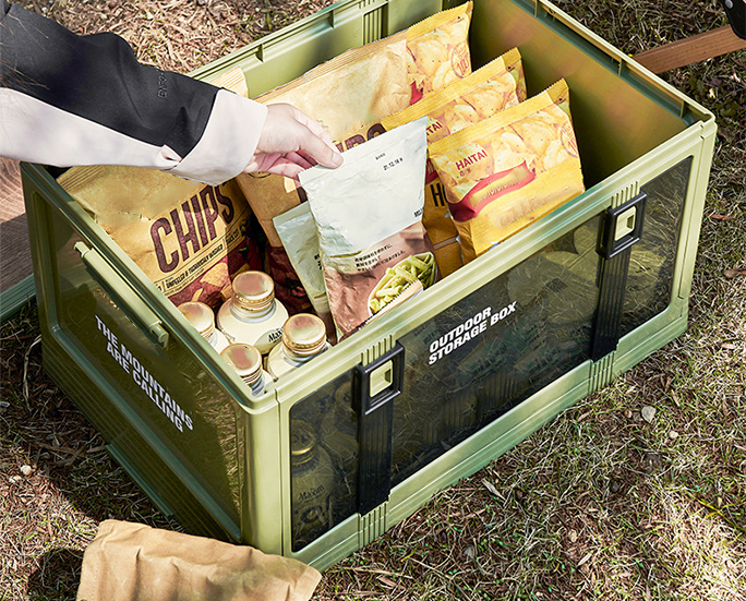 Open camping storage box filled with snacks and drinks.