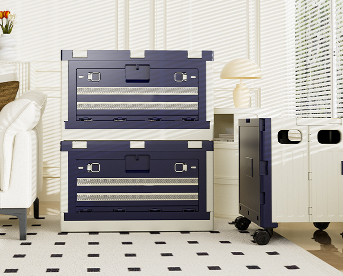 Two stacked foldable storage bins with navy blue front panels in a bright living room