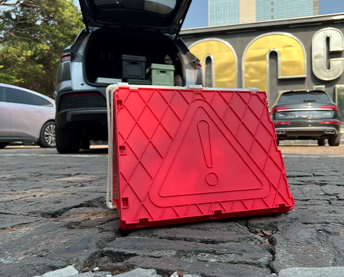 Foldable storage box with red warning symbol used as roadside emergency marker