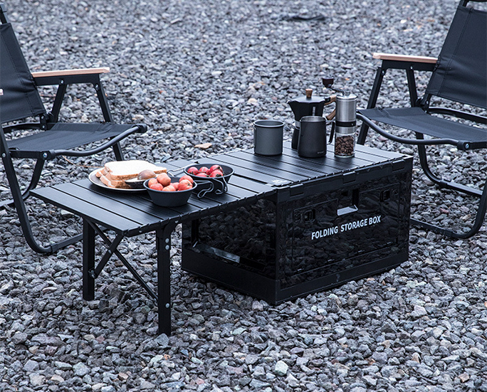 Black folding box with food and drinks used as a mini table at campsite
