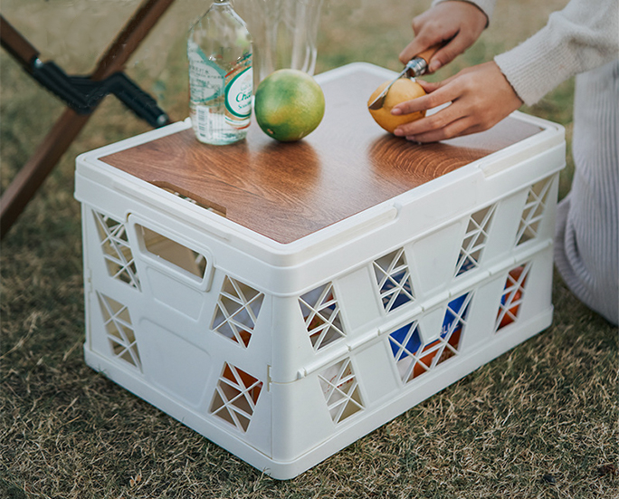 White folding basket used during a picnic with food and drinks
