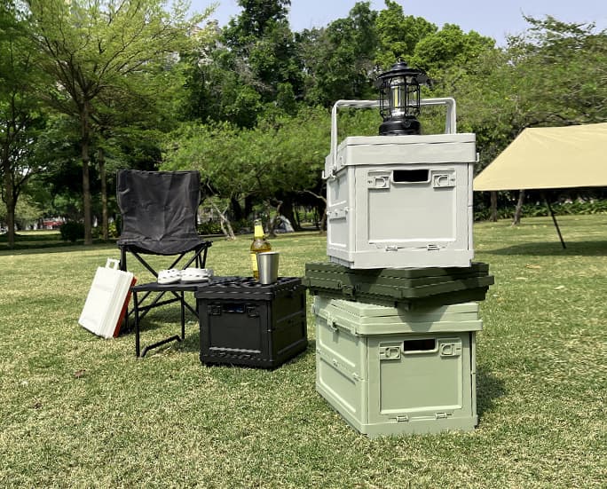 Camping setup with collapsible storage boxes, folding table, and lantern