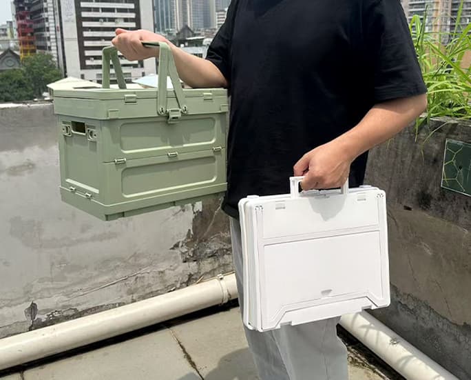 Man holding foldable camping storage boxes – one unfolded and one collapsed
