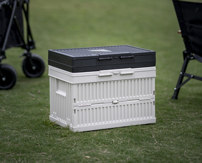 Collapsible white camping storage box with folded black box on top