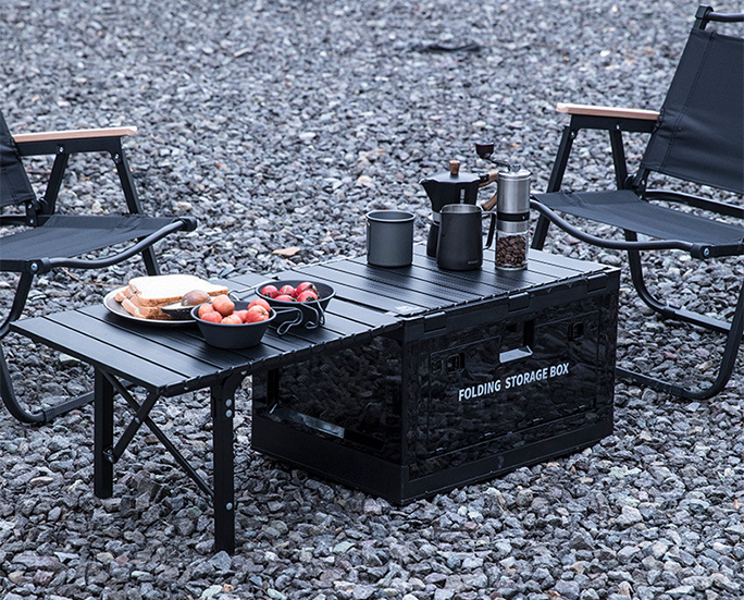 Foldable plastic box functioning as a dual-use table and storage in an outdoor setup