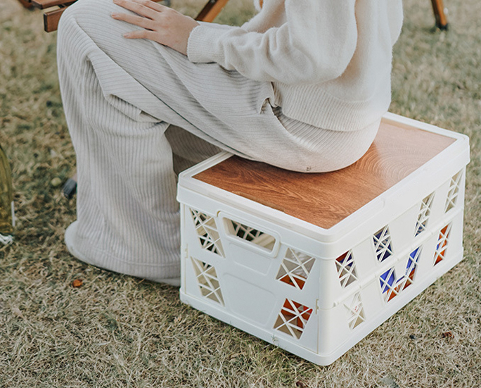 White crate being carried filled with bottled drinks