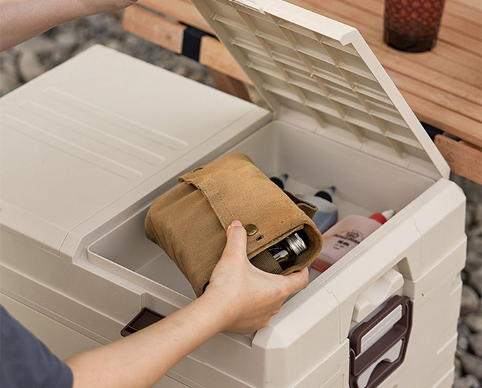 Hand accessing items from an open folding storage crate