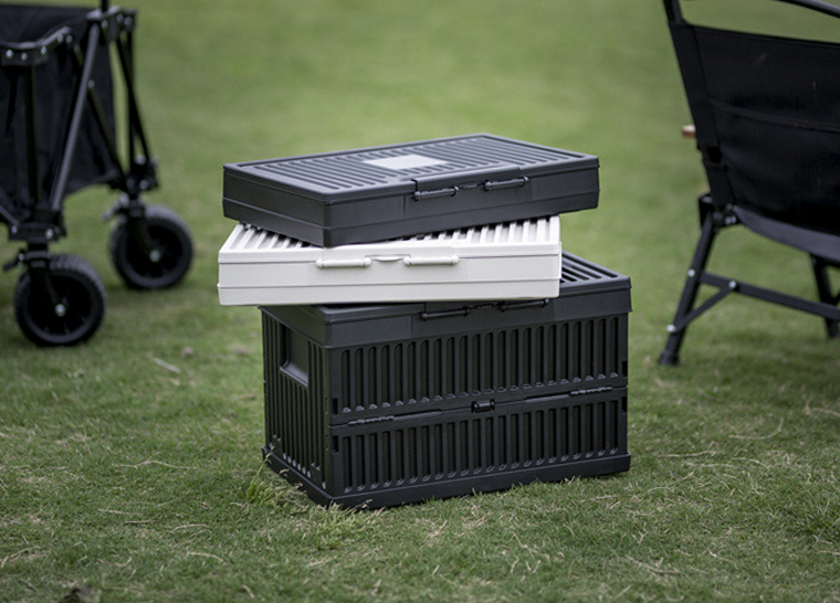 Black storage box with stacked white and black lids beside it