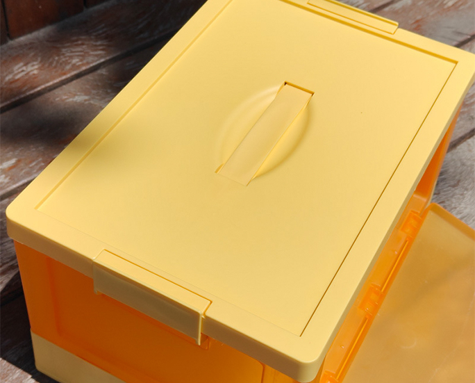 Top view of yellow plastic storage box with built-in handle