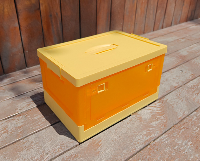Angled side view of yellow plastic storage crate under sunlight