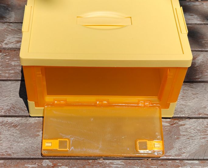 Top-down photo of open yellow storage box with front flap down