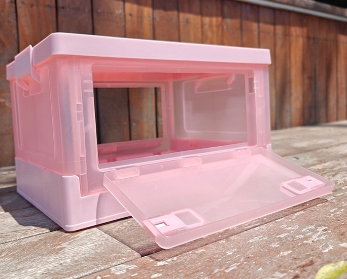 Backyard setup with pink folding plastic storage box opened fully