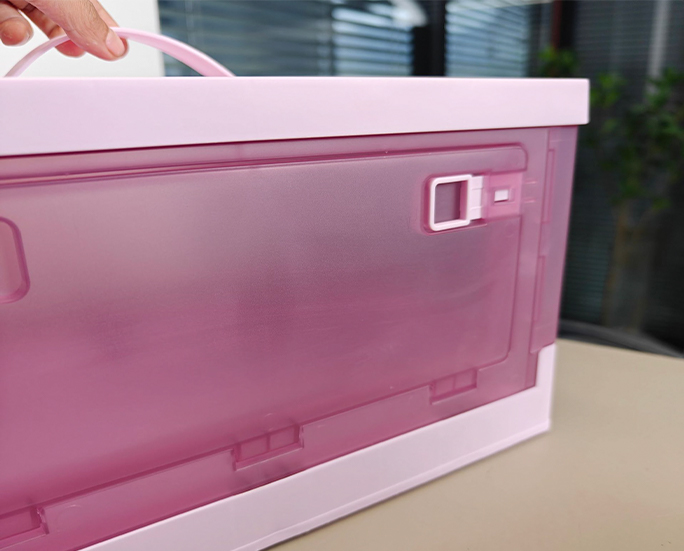 Close-up of pink storage box with hand lifting top handle