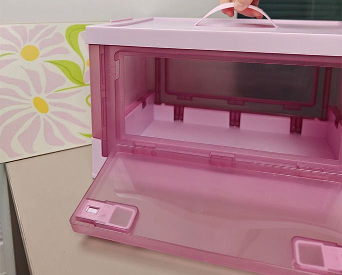 Pink plastic storage box with open front door showing inner space
