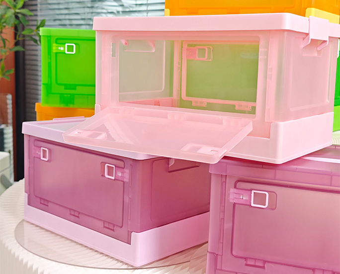 Pink and rose-red storage boxes stacked with one door open