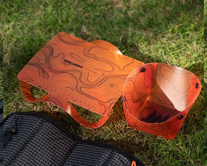 Mesa de camping plegable naranja con cesta a juego